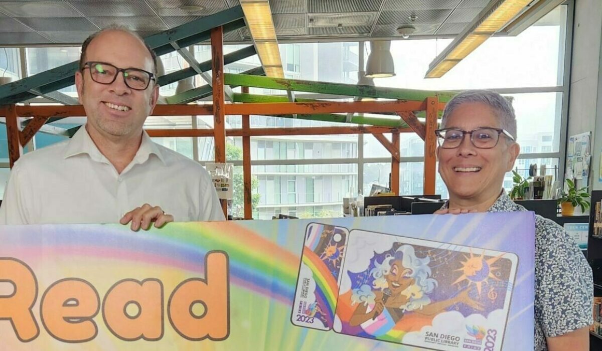 Image contains: Patrick Stewart and Dr Kim Fountain holding up a 'Read with Pride' sign for Overdue.